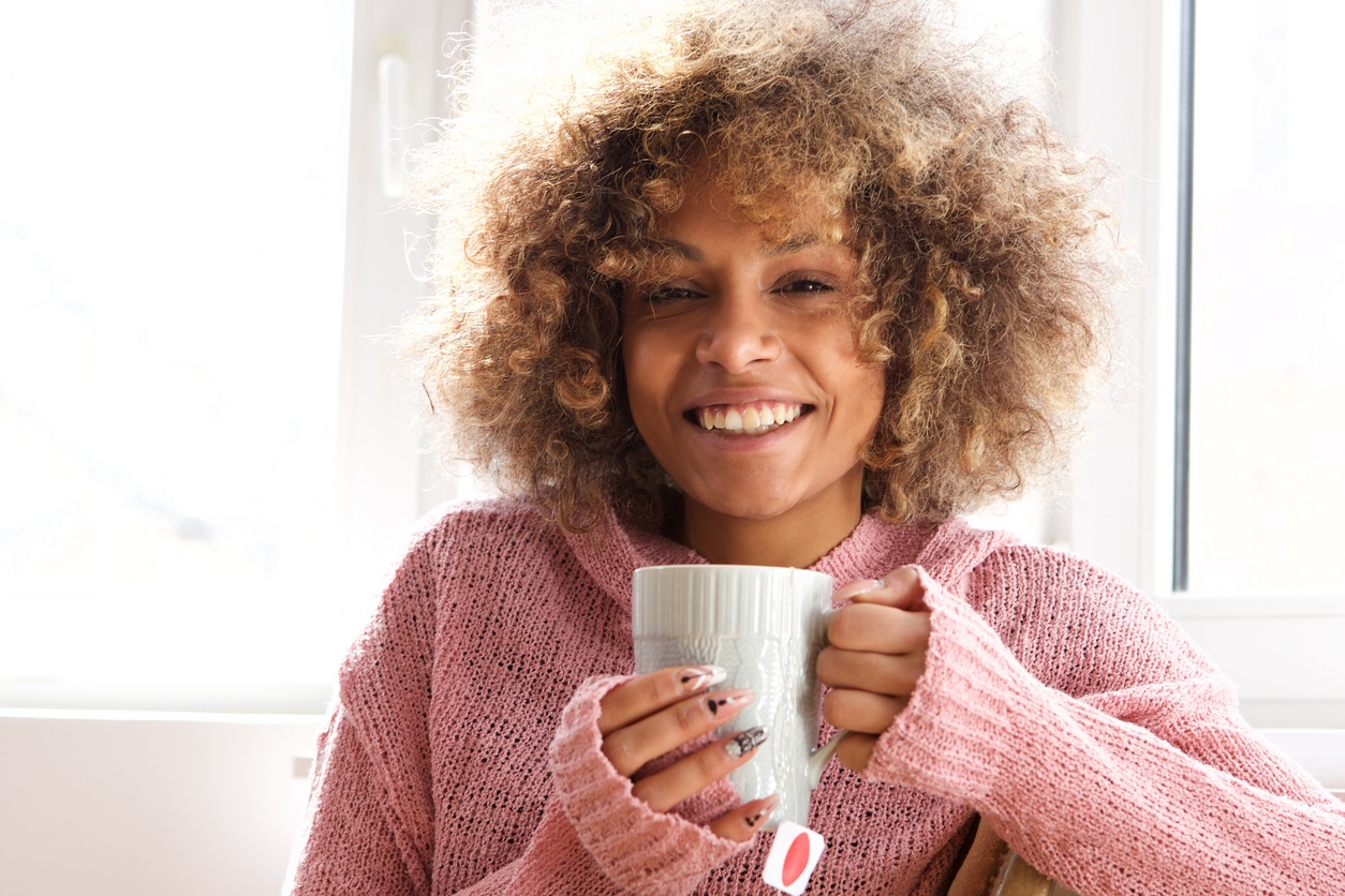 Portrait of smiling young woman with cup of tea